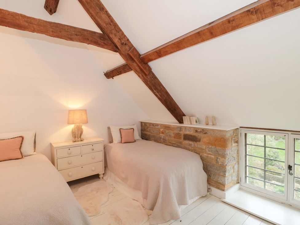 A bedroom with two beds and a lamp at The Farmhouse in Langport