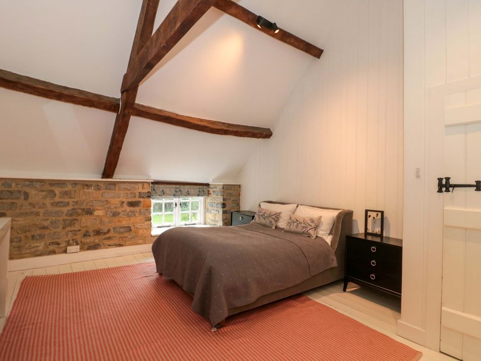 A bedroom with a bed and wooden beams at The Farmhouse in Langport