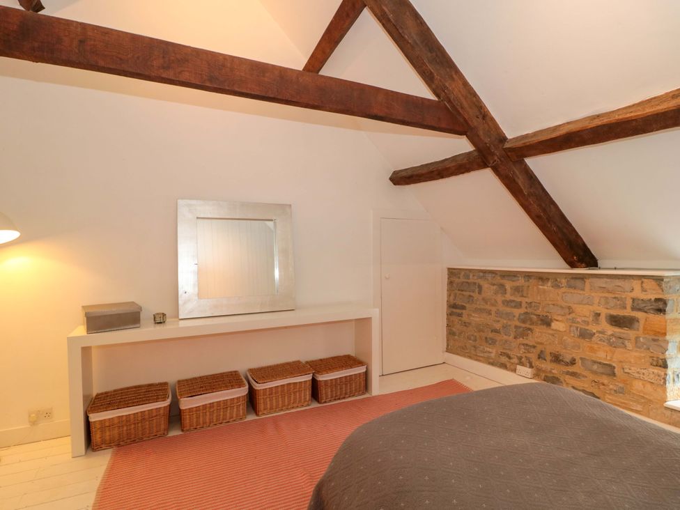 A bedroom with a mirror and storage baskets at The Farmhouse in Langport