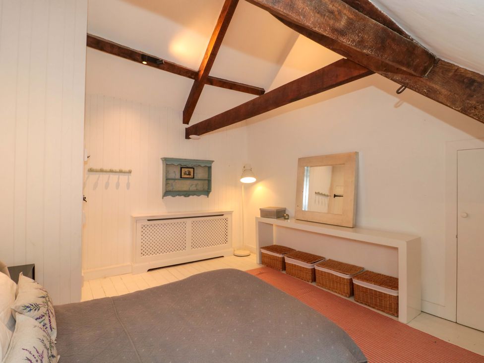 A bedroom with a bed and a mirror at The Farmhouse in Langport