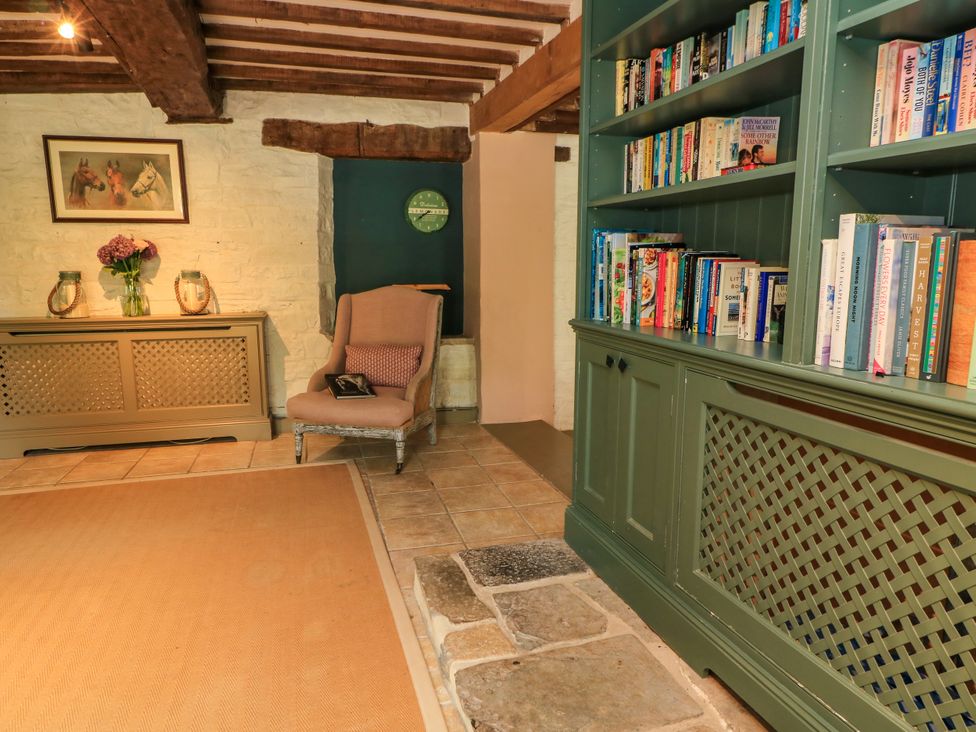 A living room with a chair and bookshelf at The Farmhouse in Langport