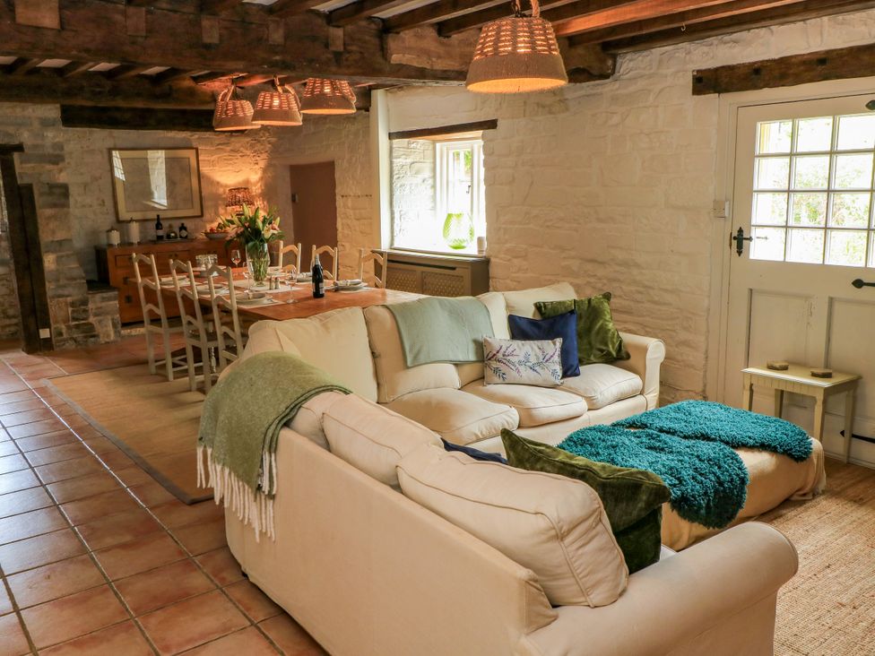 A living room with a sofa and dining area at The Farmhouse in Langport