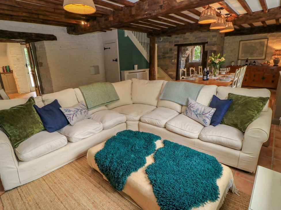 A living room with a sofa and a dining area at The Farmhouse in Langport