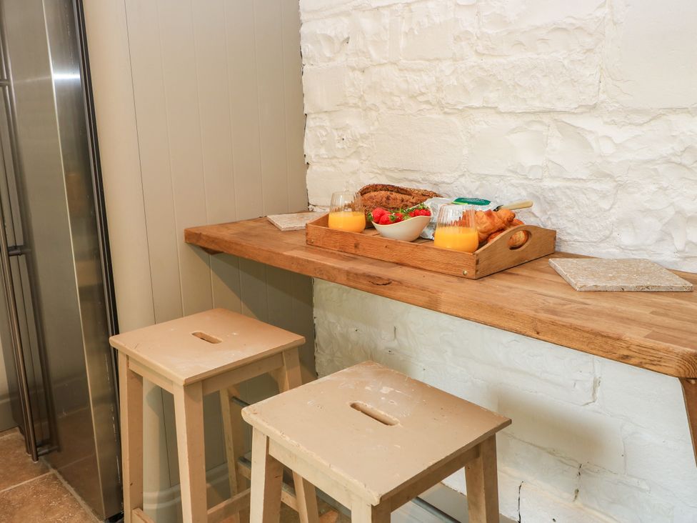 A kitchen with a wooden table and food items at The Farmhouse in Langport