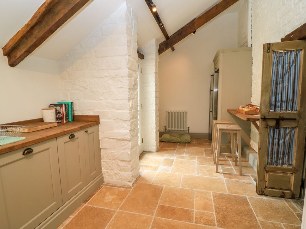 A kitchen with cabinets and a refrigerator at The Farmhouse in Langport