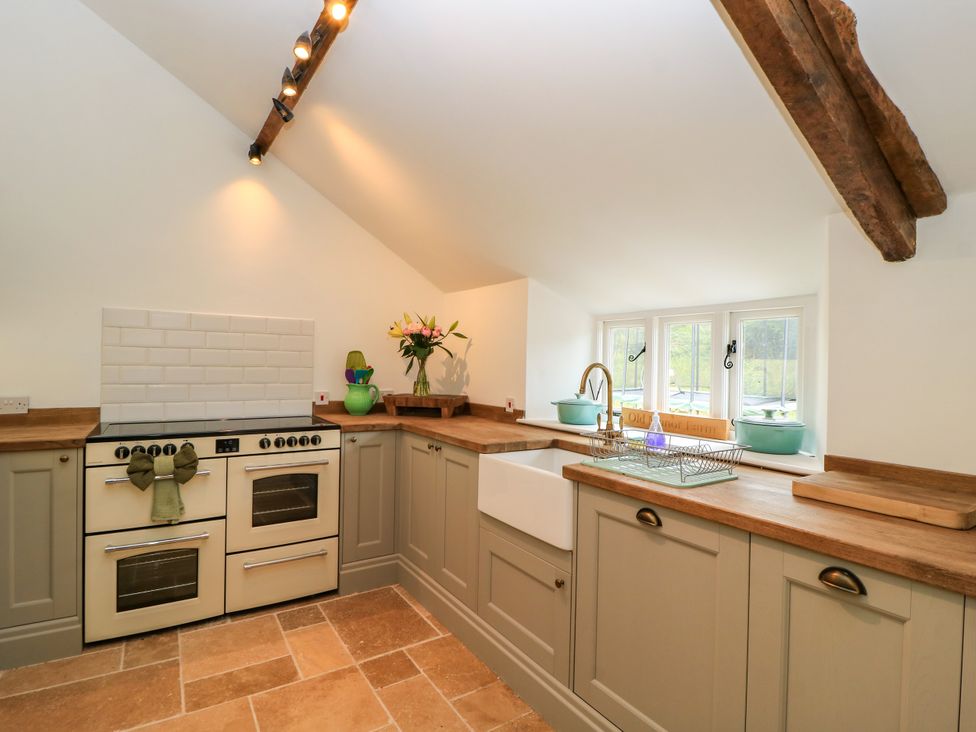 A kitchen with a sink and oven at The Farmhouse in Langport