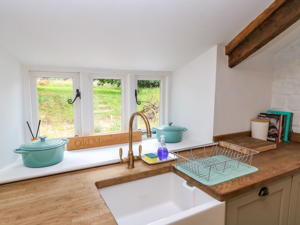 A kitchen with a sink and cooking pots at The Farmhouse in Langport