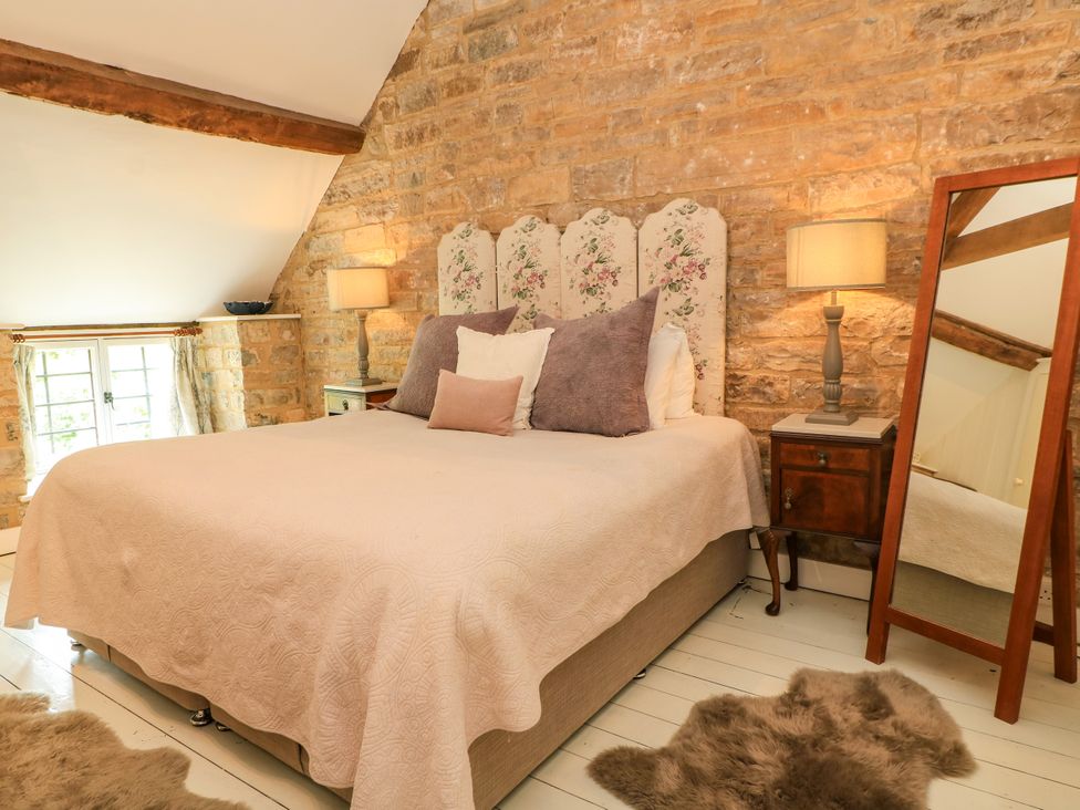 A bedroom with a bed and nightstand at The Farmhouse in Langport