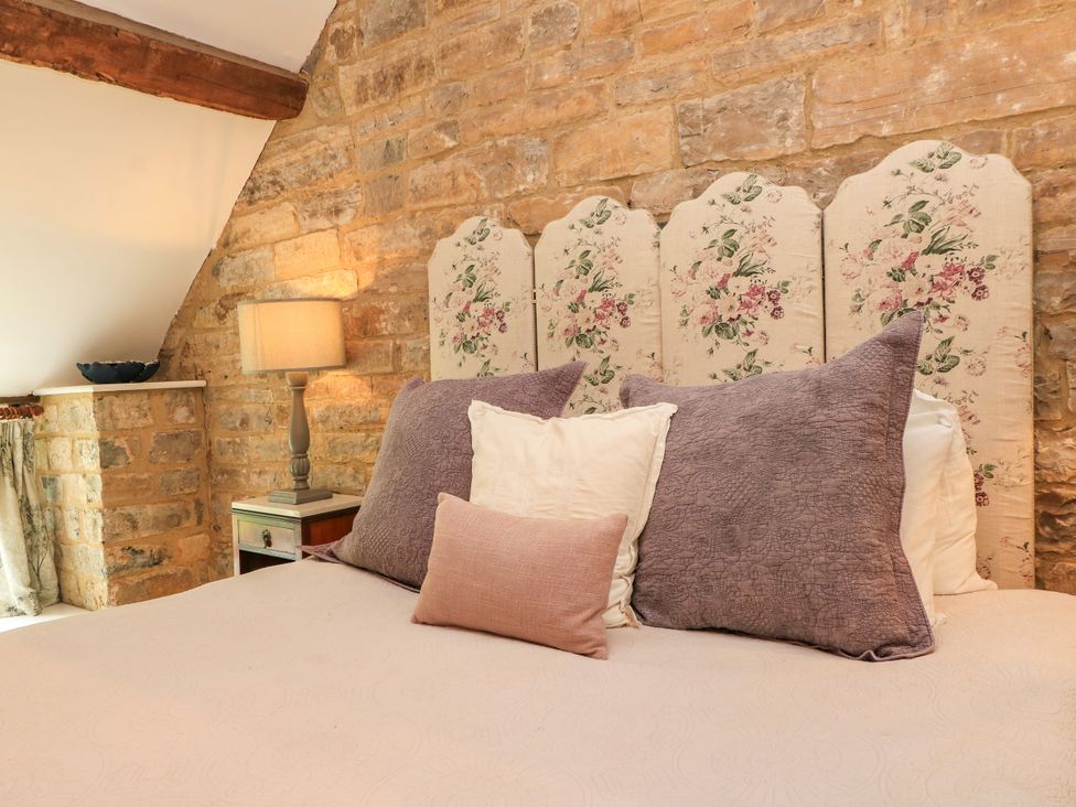A bedroom with a bed and stone walls at The Farmhouse in Langport