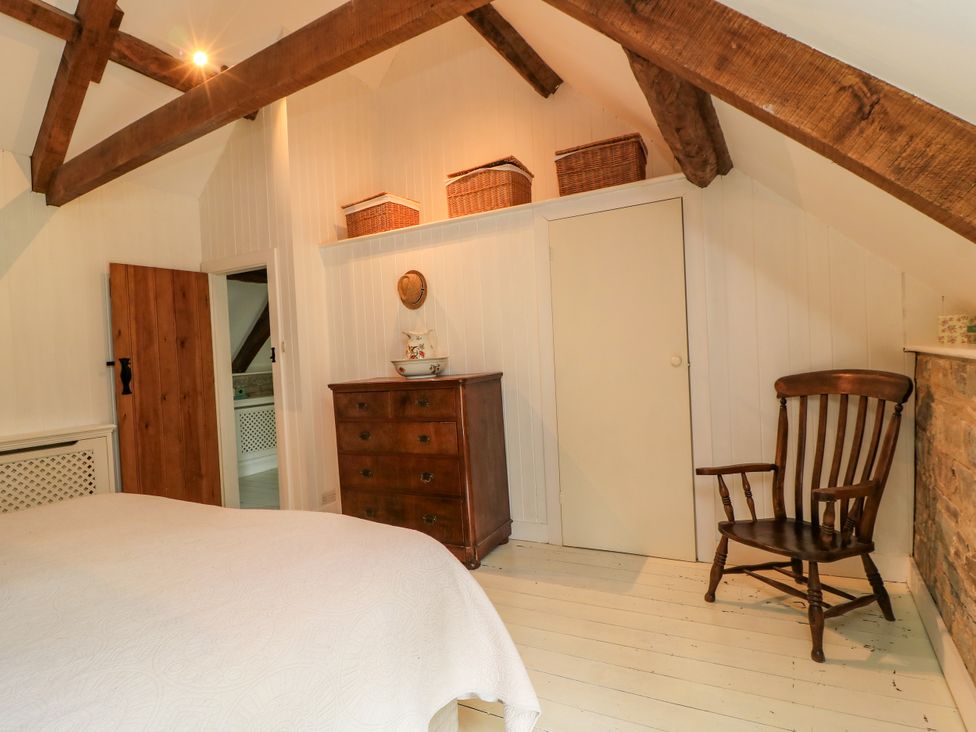 A bedroom with a bed, dresser, and chair at The Farmhouse in Langport