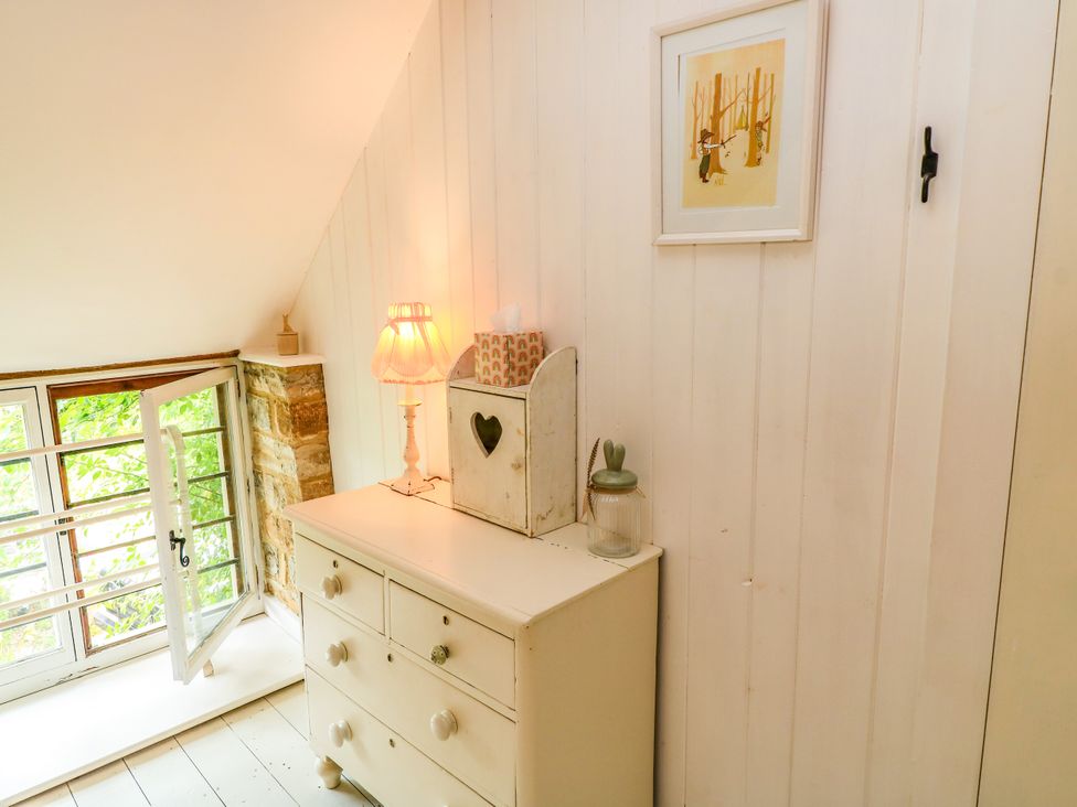 A bedroom with a chest of drawers and window at The Farmhouse in Langport