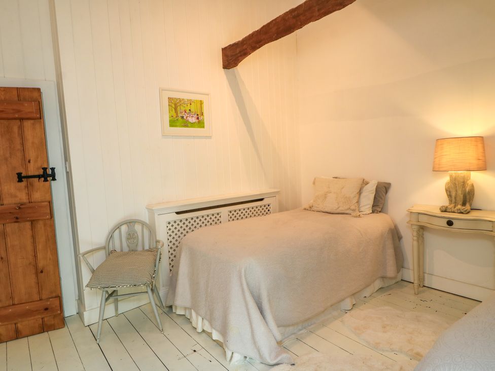 A bedroom with a bed and a nightstand at The Farmhouse in Langport