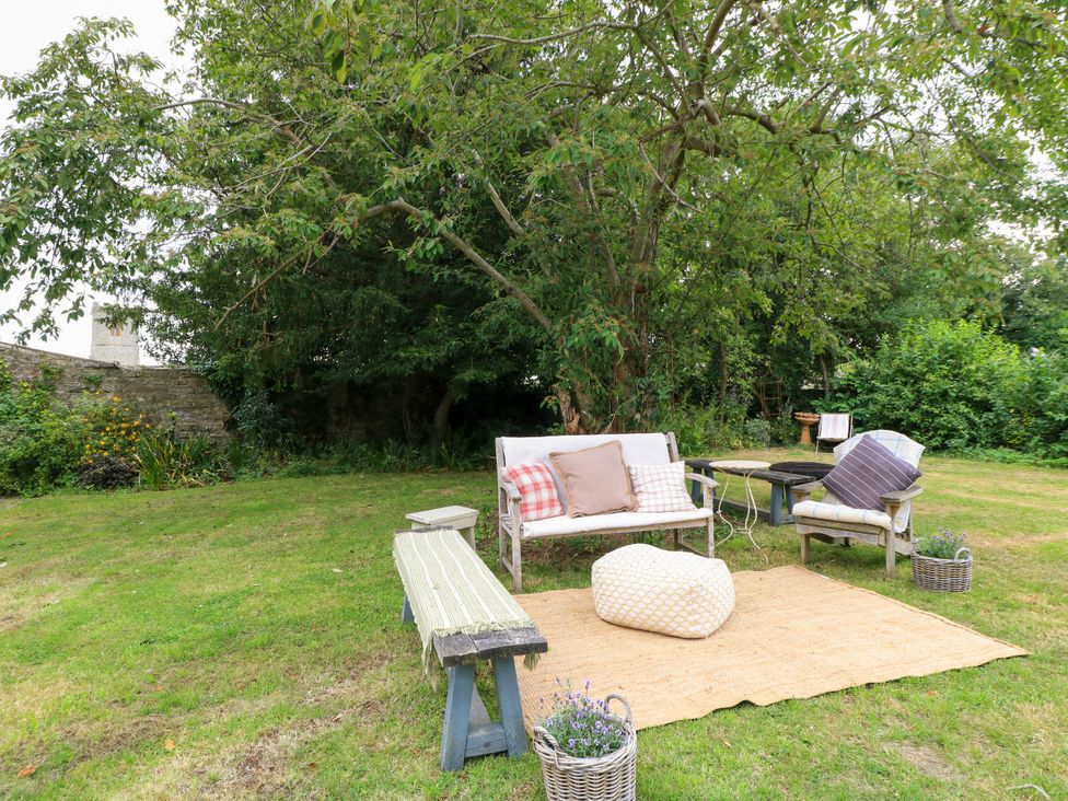 A garden area with seating and a rug at The Farmhouse in Langport