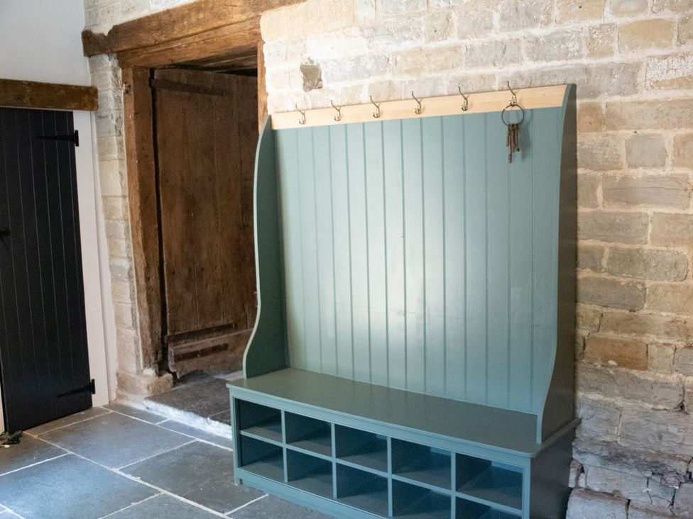 An entryway with a bench and hooks at The Farmhouse in Langport