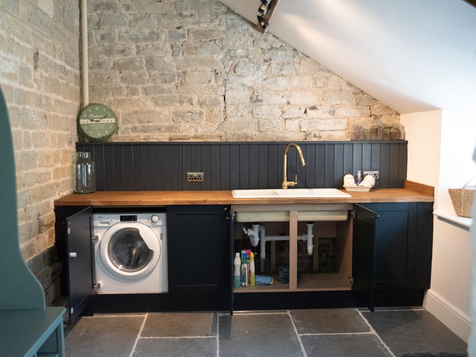 A laundry room with a washing machine and sink at The Farmhouse in Langport