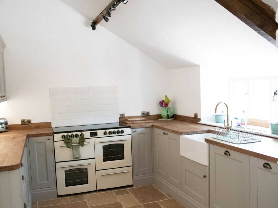 A kitchen with an oven and sink at The Farmhouse in Langport