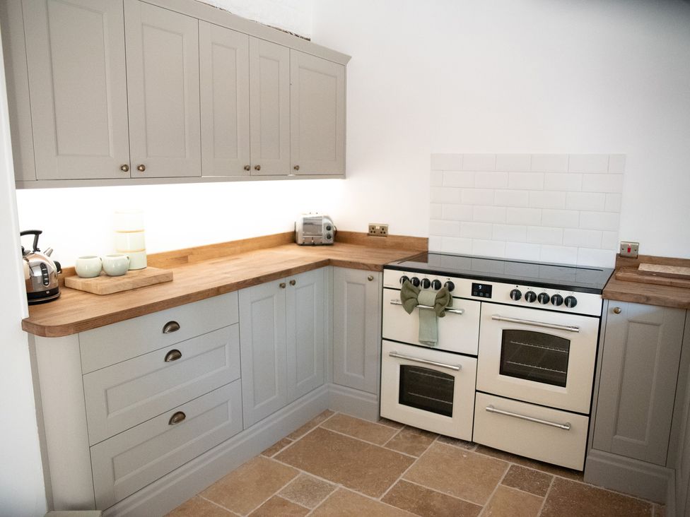 A kitchen with cabinets and an oven at The Farmhouse in Langport