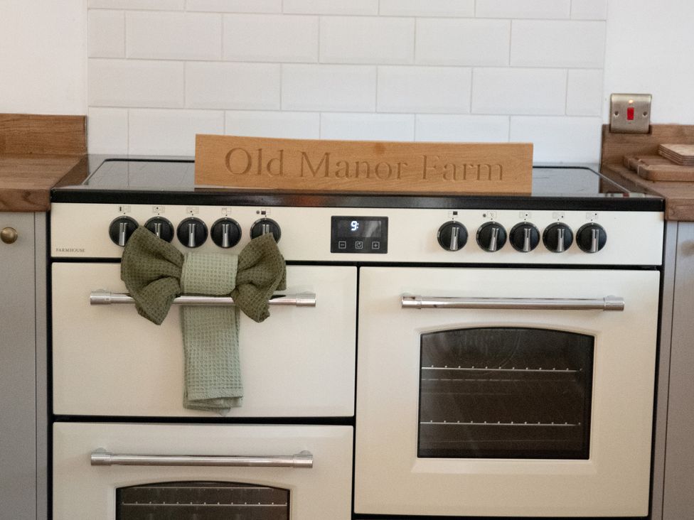 A stove with a decorative sign and towel at Old Manor Farm in Langport