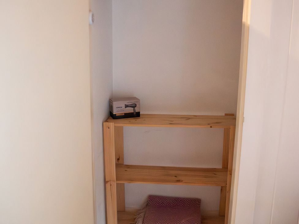 A storage room with a shelf and a box at The Farmhouse in Langport