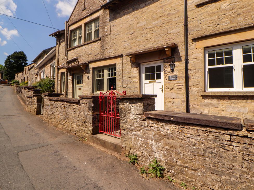 A stone house with a red gate at East View in Kirkby Stephen