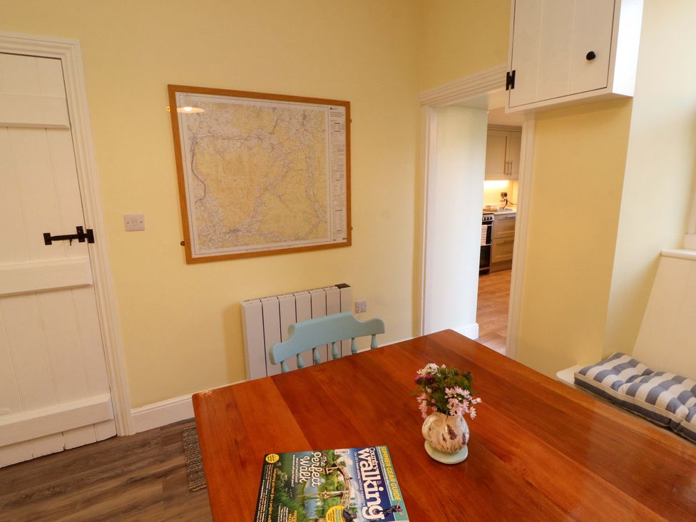A dining room with a table and a map on the wall at East View in Kirkby Stephen