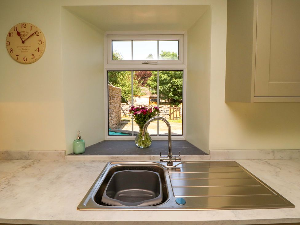 A kitchen sink with a tap and a vase on the counter at East View in Kirkby Stephen