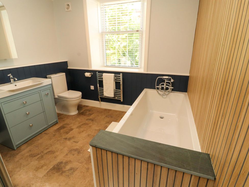 A bathroom with a bathtub, toilet, and sink at East View in Kirkby Stephen