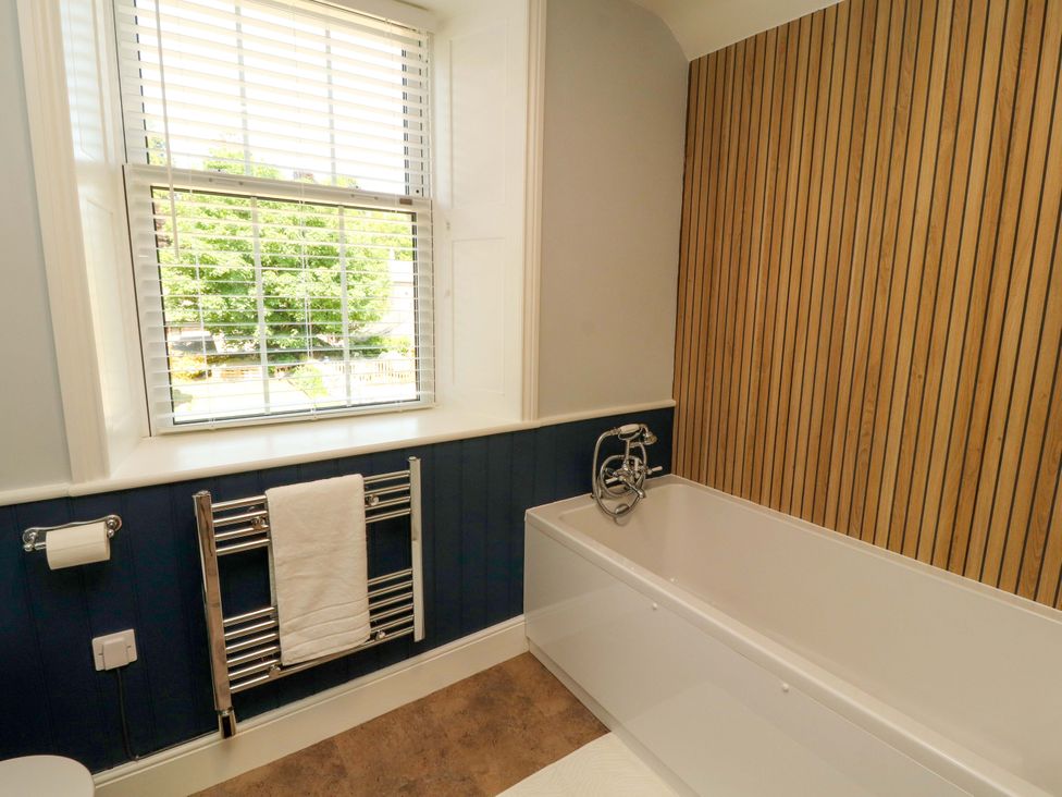 A bathroom with a bathtub and towel rail at East View in Kirkby Stephen