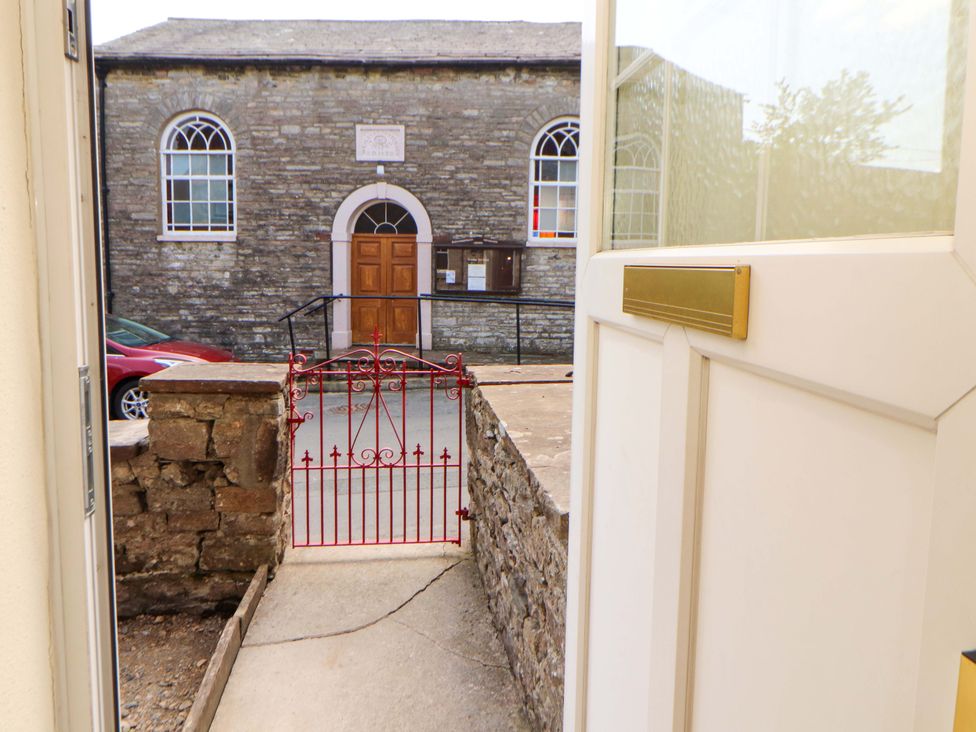 A view of a red gate leading to a stone building at East View, Kirkby Stephen
