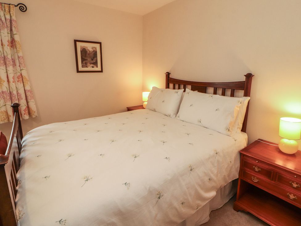 A bedroom with a bed and nightstand at East View in Ravenstonedale near Kirkby Stephen