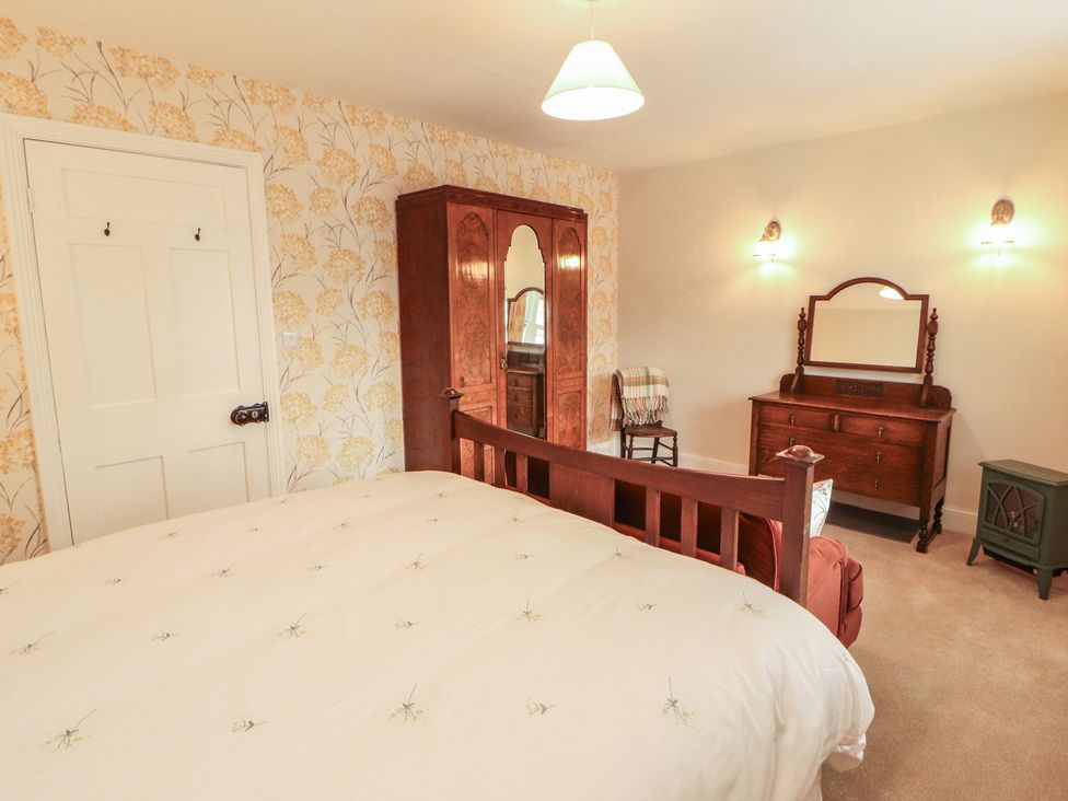 A bedroom with a bed and wardrobe at East View in Ravenstonedale near Kirkby Stephen