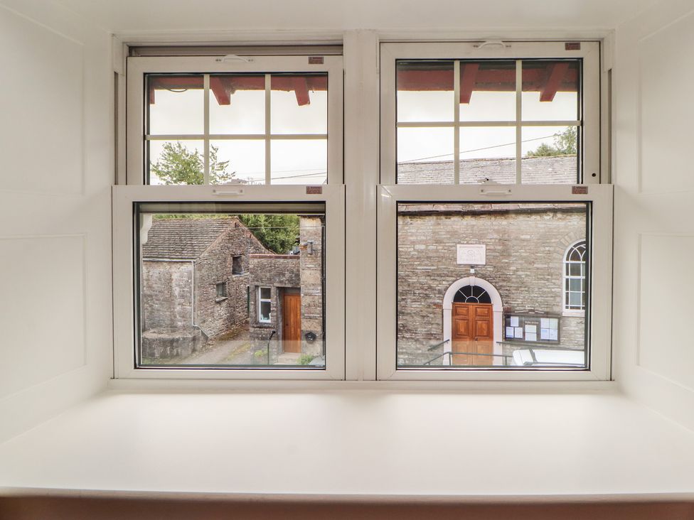 A window view showing a door and stone buildings at East View in Ravenstonedale near Kirkby Stephen