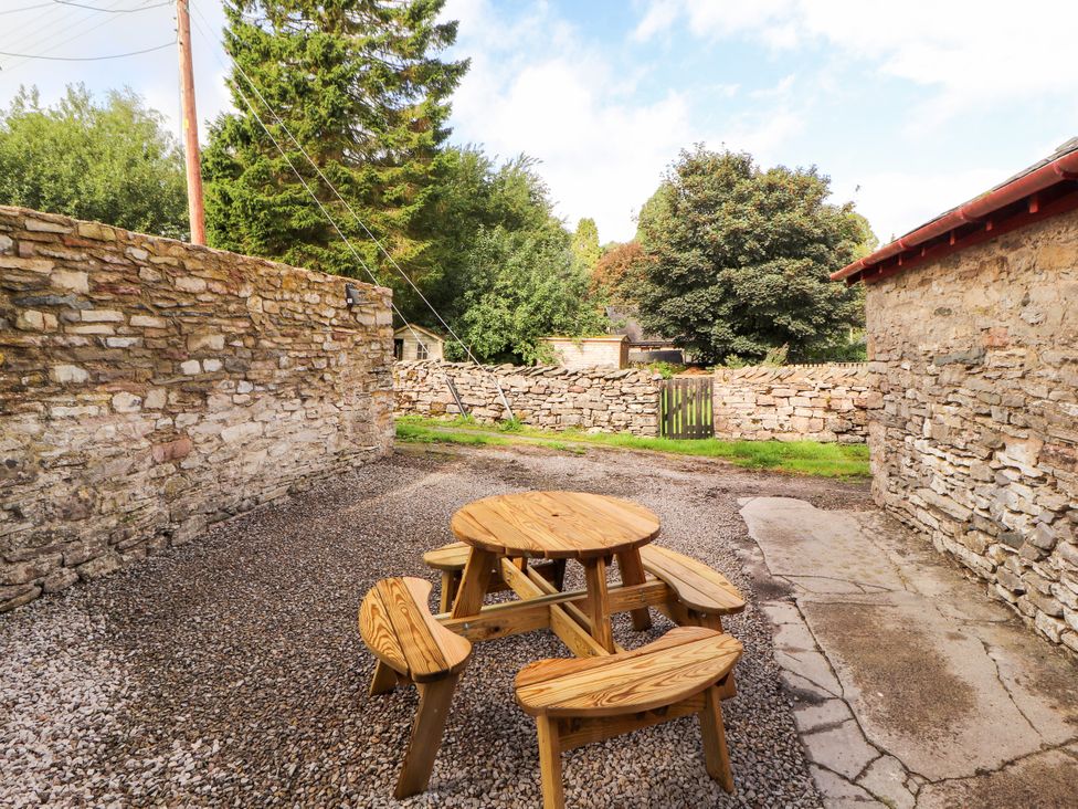 An outdoor area with a wooden table and benches at East View in Ravenstonedale near Kirkby Stephen