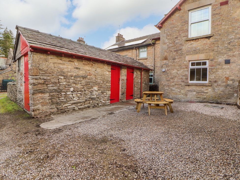 An outdoor area with a stone building and table seating at East View in Ravenstonedale near Kirkby Stephen