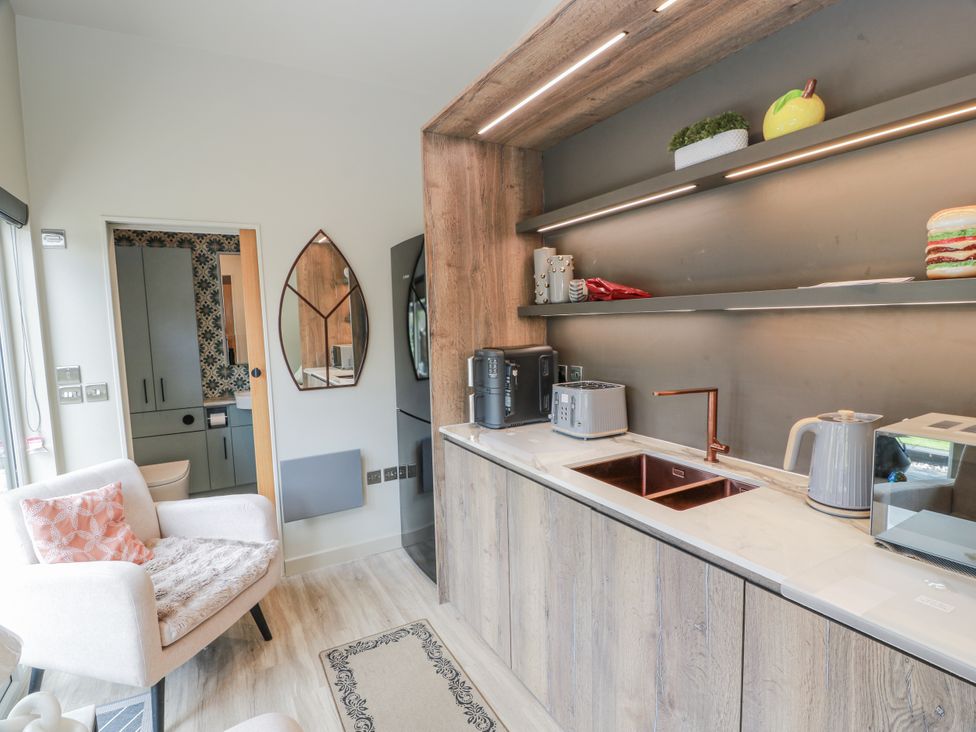 A kitchen with cabinets, sink, and appliances at Cabin At The Brig Annan