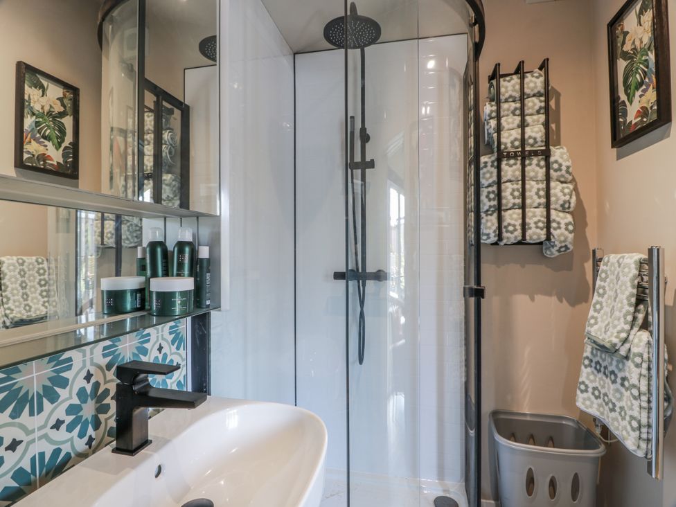 A bathroom with a shower and sink at Cabin At The Brig in Annan