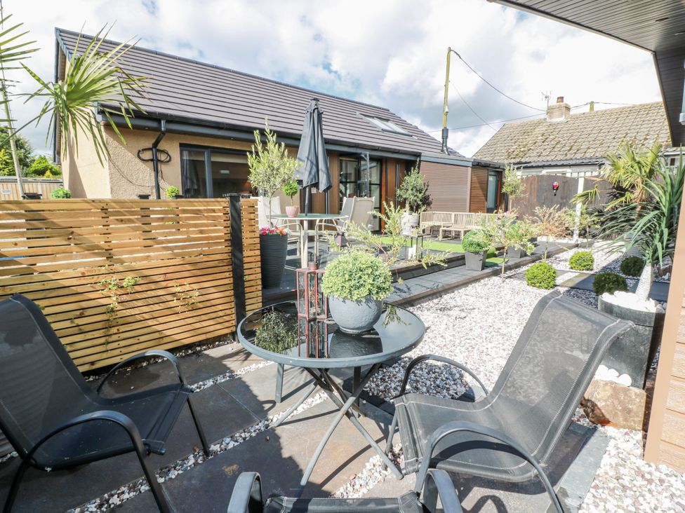 An outdoor seating area with a table and chairs at Cabin At The Brig in Annan