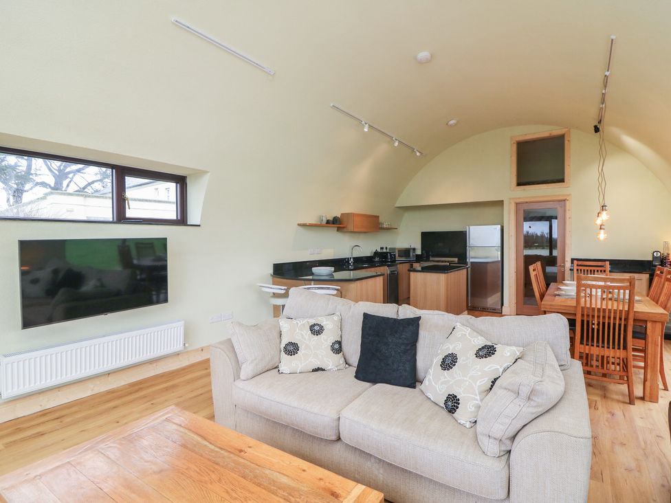 A living room with a sofa and dining area at The Rookery Rosslare Harbour, County Wexford