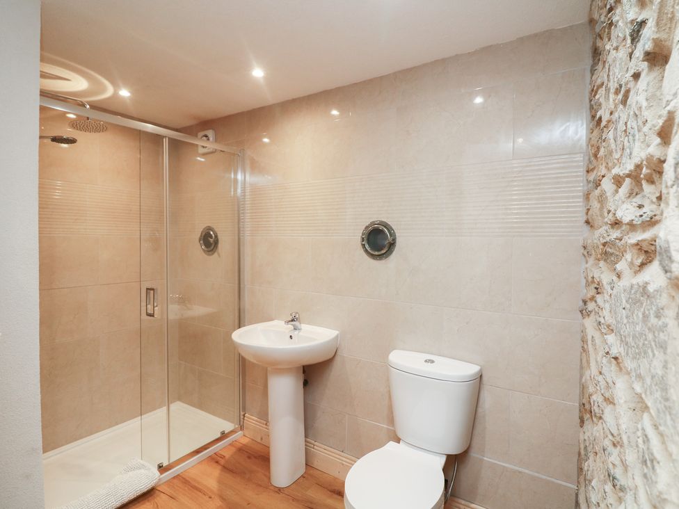 A bathroom with a shower, toilet, and sink at The Rookery in Rosslare Harbour, County Wexford