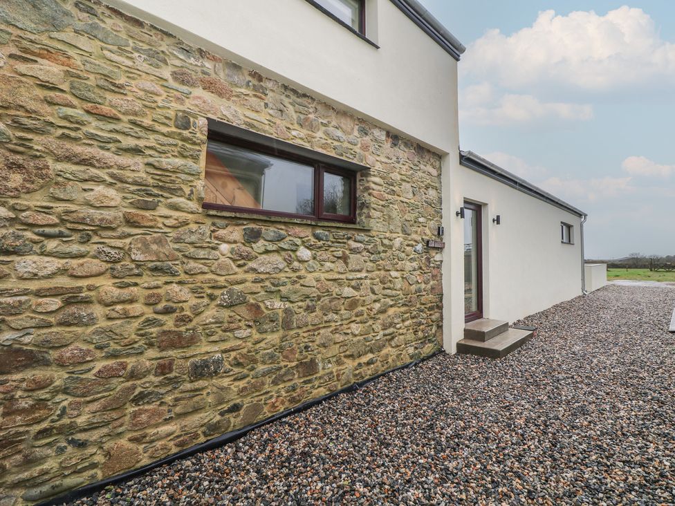 An exterior view of a house with a stone wall and gravel pathway at The Rookery Rosslare Harbour, County Wexford