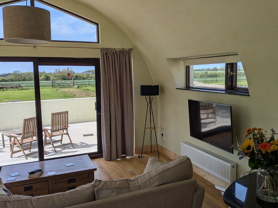 A living room with a sofa and television at The Rookery in Rosslare Harbour, County Wexford