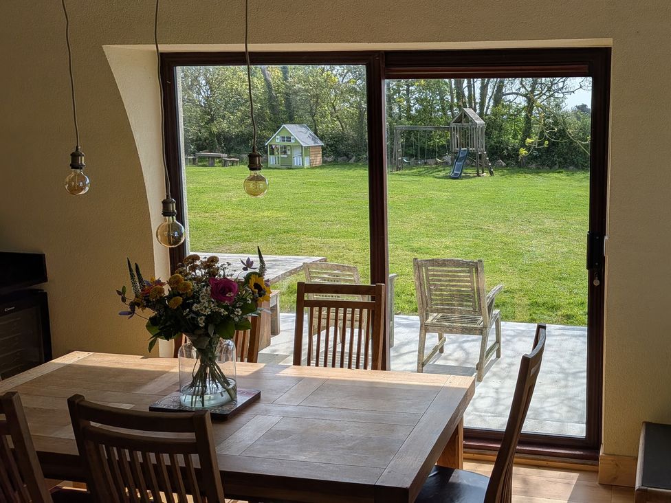 A dining room with a view of the garden and playground at The Rookery in Rosslare Harbour, County Wexford