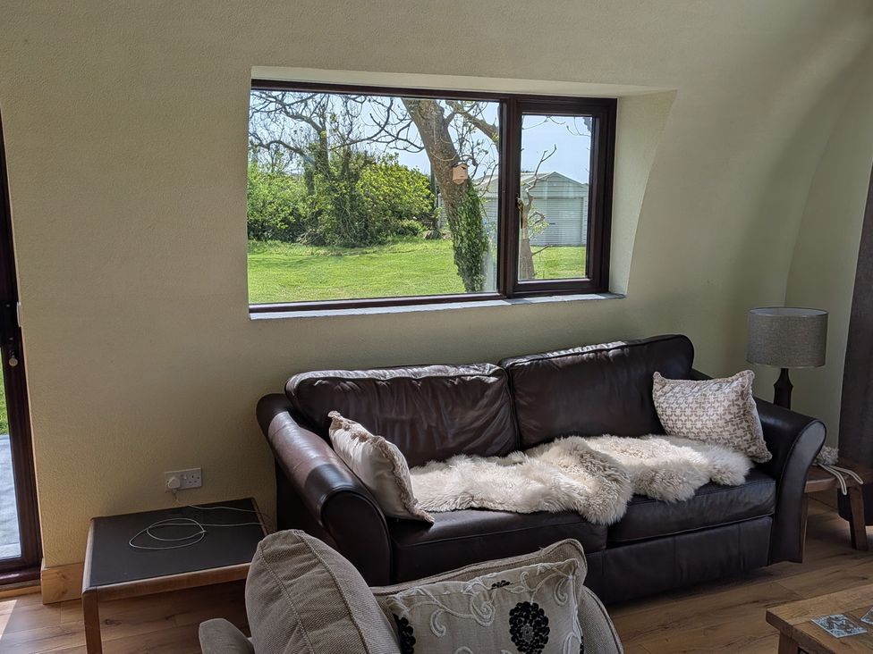 A living room with a sofa and window at The Rookery in Rosslare Harbour, County Wexford