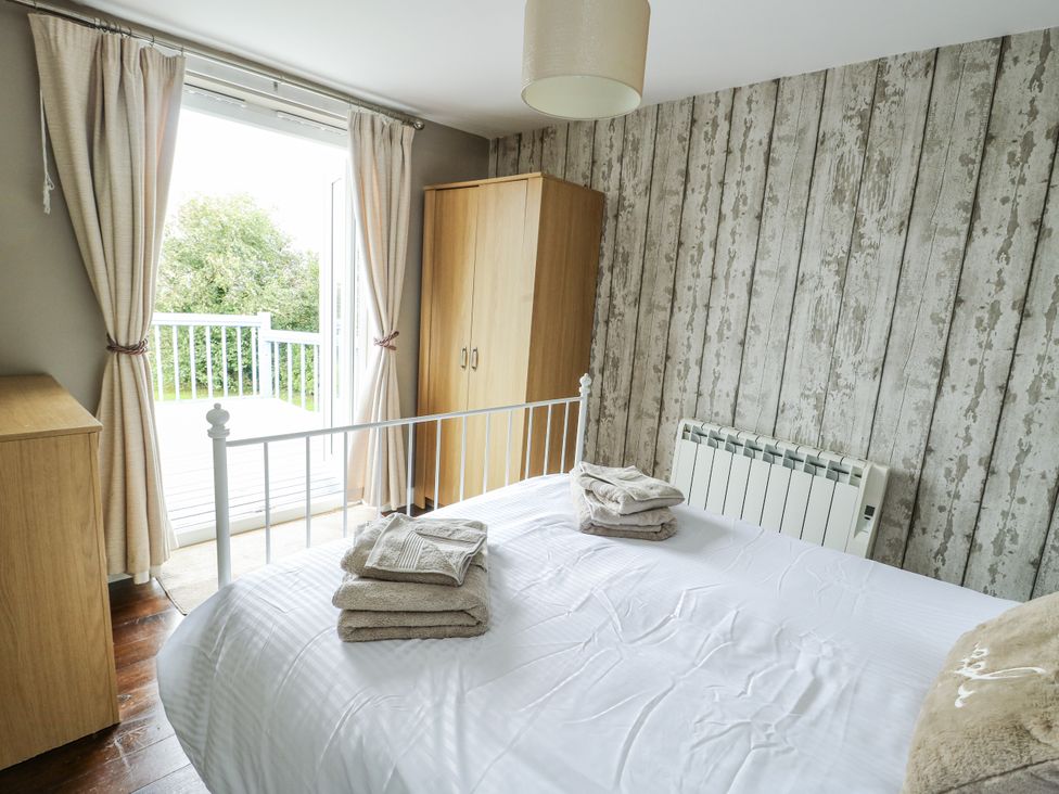 A bedroom with a bed and wardrobe at Harbour Lights in Holyhead