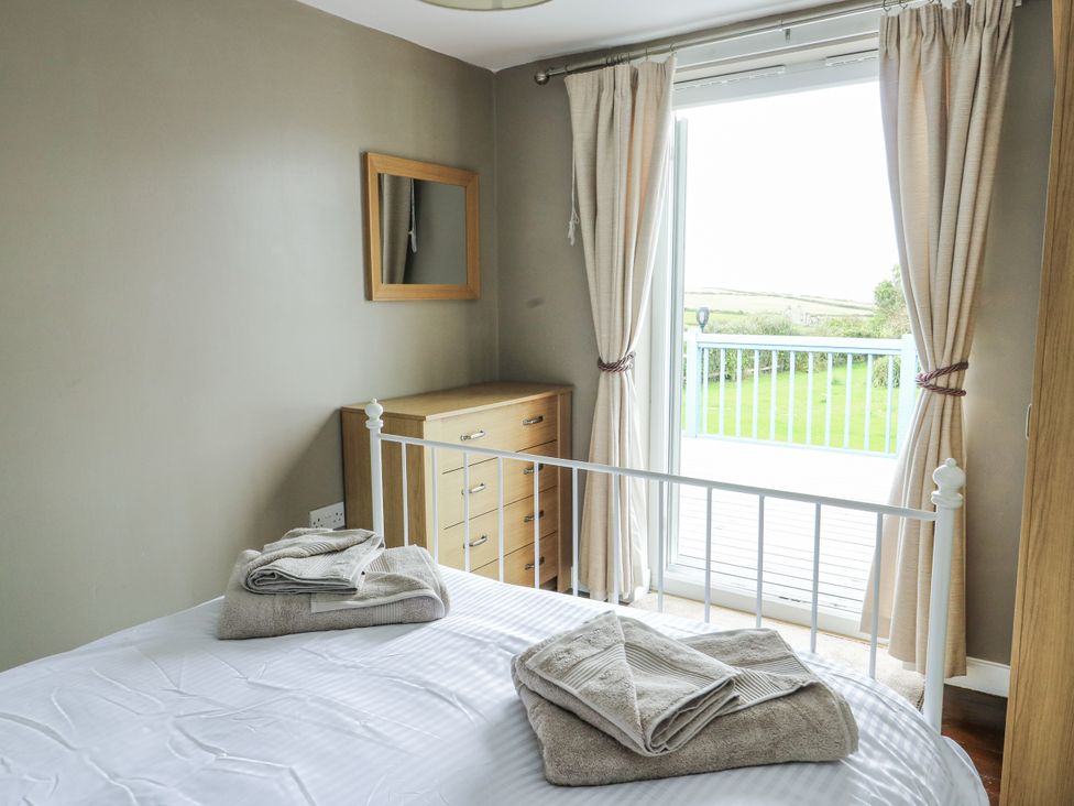 A bedroom with a bed and dresser at Harbour Lights in Holyhead