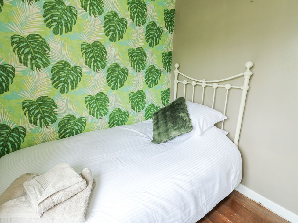 A bedroom with a bed and decorative wallpaper at Harbour Lights in Holyhead
