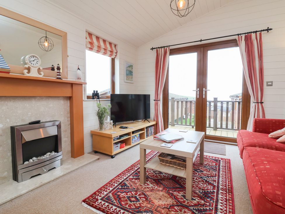 A living room with a fireplace and television at Ocean Terrace 28 in Ilfracombe