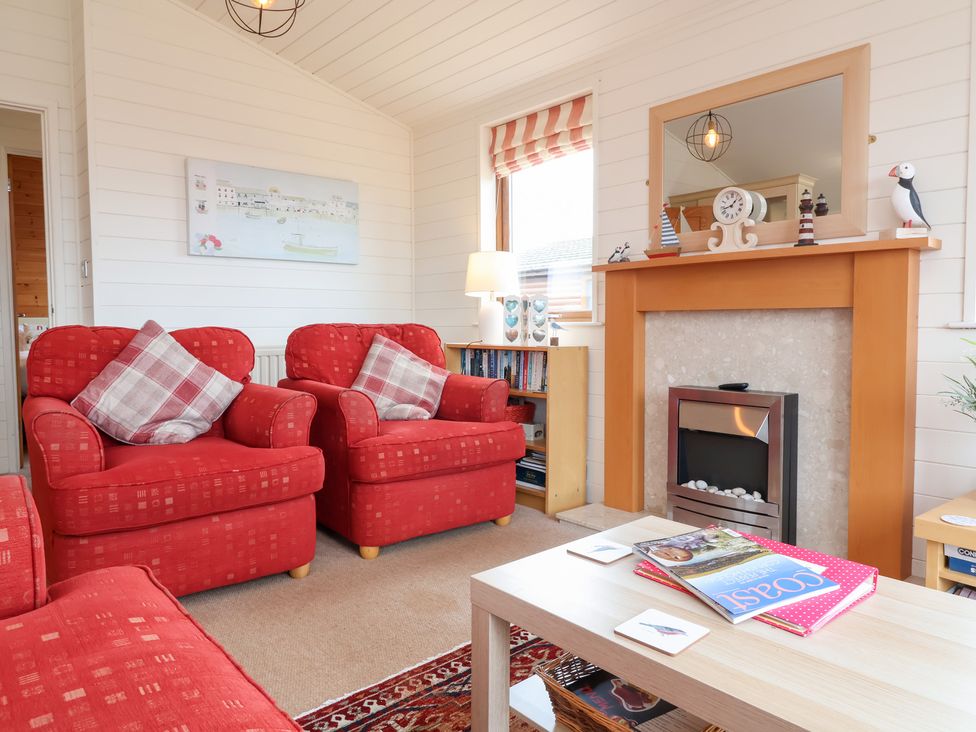 A living room with armchairs and a fireplace at Ocean Terrace 28 Ilfracombe