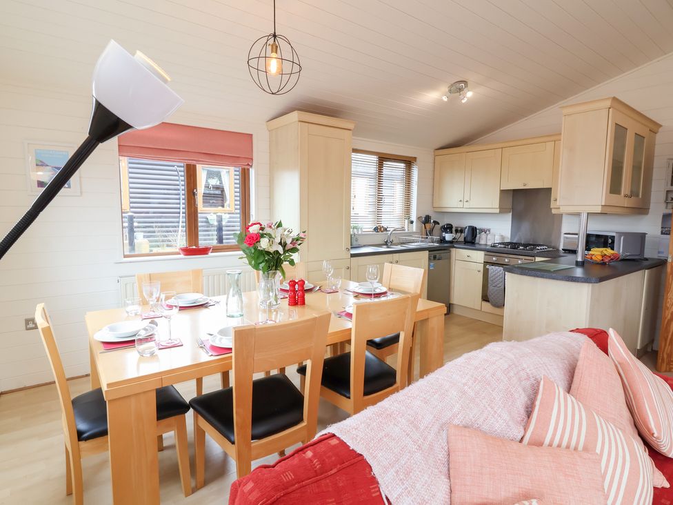A kitchen with dining table and appliances at Ocean Terrace 28 in Ilfracombe