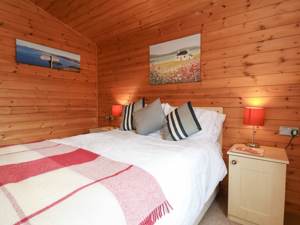 A bedroom with a bed and nightstand at Ocean Terrace 28 Ilfracombe